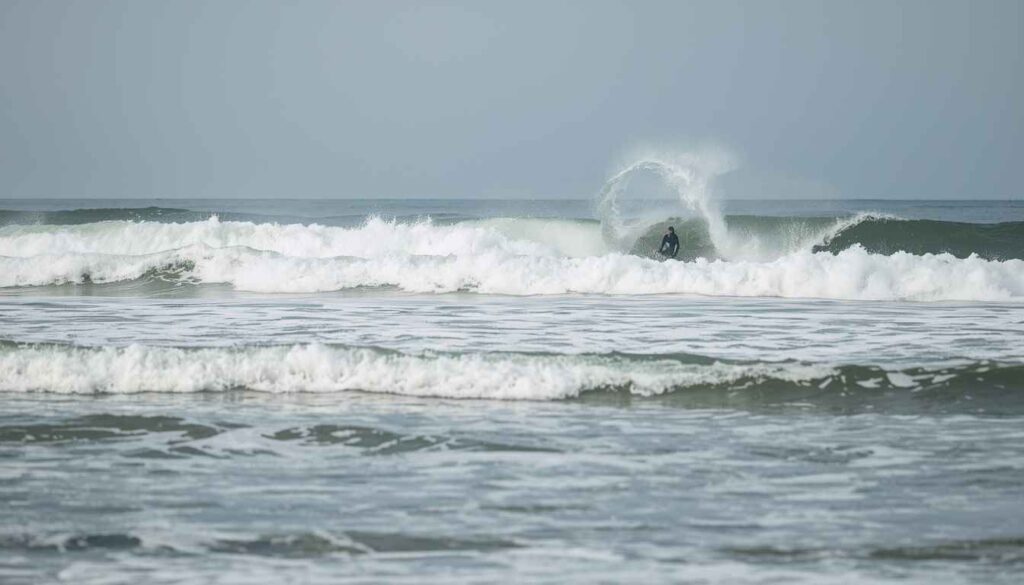 Seminyak beach during February rainy season with surfers enjoying consistent waves