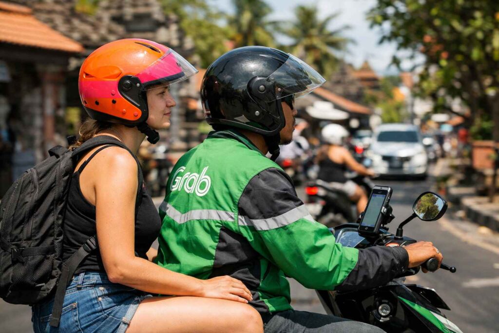 Safe Grab motorbike transport for solo women travelers in Kuta Bali showing helmet and driver
